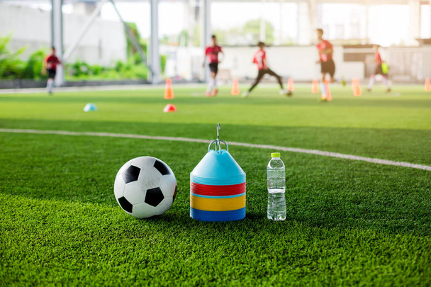 サッカー ボール、マーカー コーン、サッカーのトレーニングのための緑の人工芝のボトル水. - 写真・画像