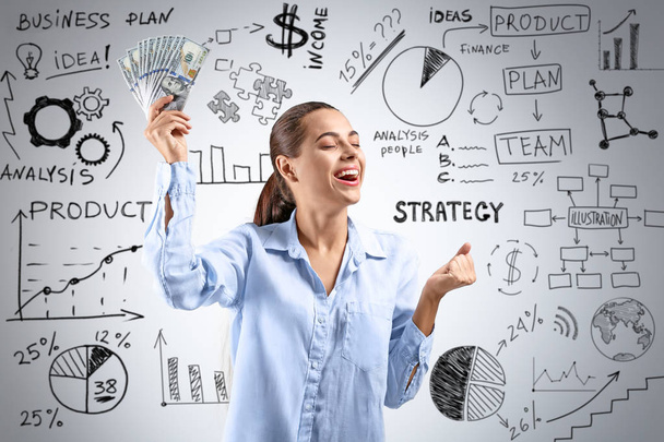 Happy successful woman with money and different drawn diagrams on light background - Photo, Image