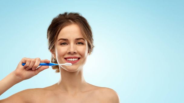 smiling woman with toothbrush cleaning teeth - Foto, Imagem