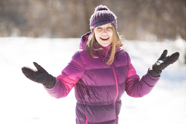 Cheerful young woman in black mittens in winter - Фото, зображення