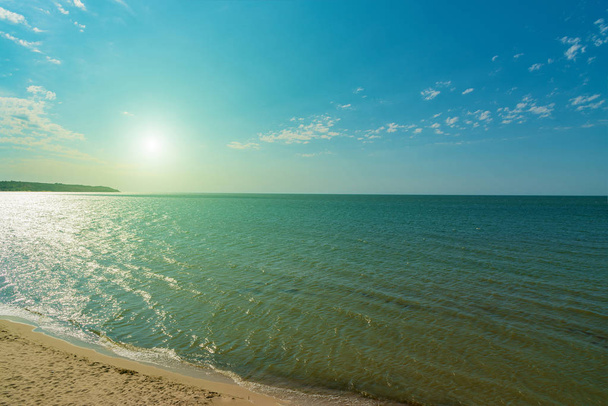 Bezludnej plaży latem do morza, widok z boku ze słońcem od góry - Zdjęcie, obraz