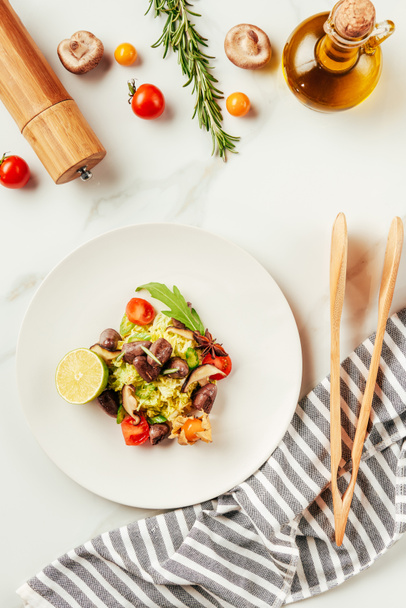 top view of salad on white plate with bottle of oil, cherry tomatoes and rosemary - Fotoğraf, Görsel