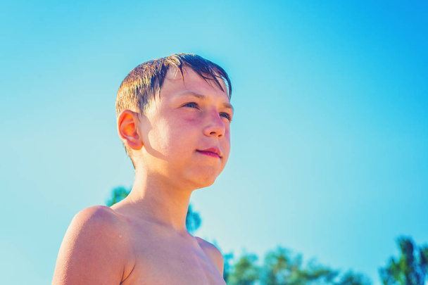 Le garçon après une baignade sur la plage, journée ensoleillée d'été
 - Photo, image