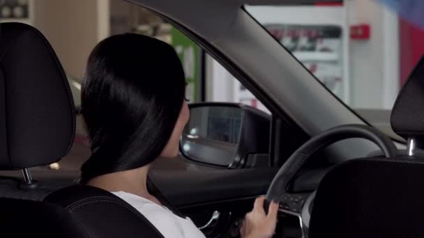 Mooie gelukkig vrouw zit in haar nieuwe auto, auto sleutel naar de camera te tonen - Video