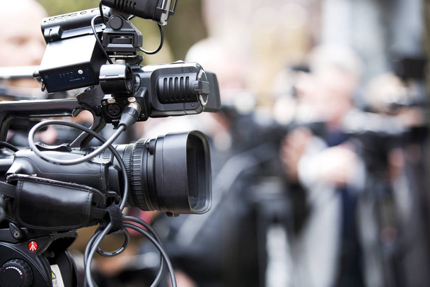 Videocamera professionale con giornalisti in background
 - Foto, immagini