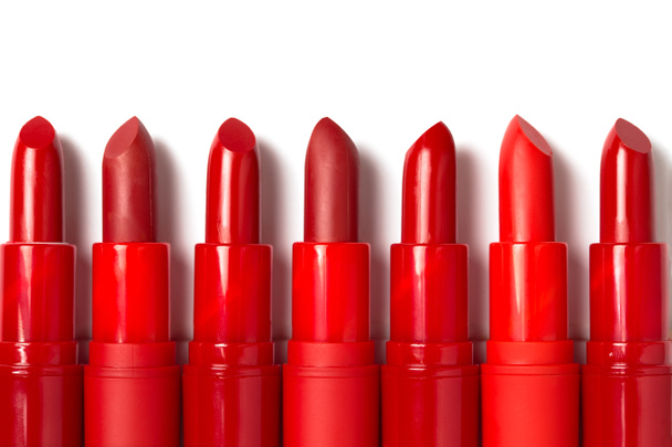 Row of red lipstick tubes with copy space isolated on white background - Photo, Image