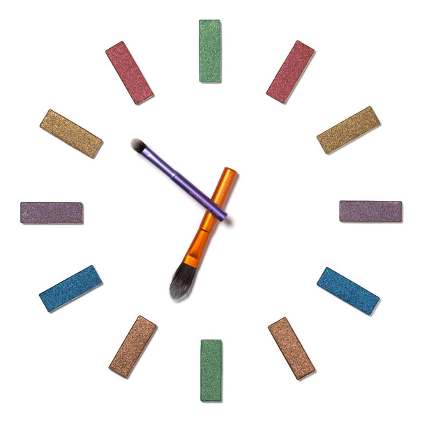 Reloj analógico hecho de sombra de ojos y cepillos aislados sobre fondo blanco. Tiempo de maquillaje a las 6: 52 am
 - Foto, Imagen