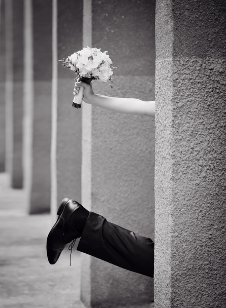 Leg of the bride and groom with a bouquet of hand, black and white - Foto, afbeelding