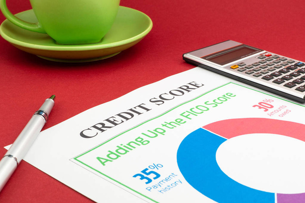 Kreditbewertungsbericht mit Tastatur und Notizblock auf rotem Tisch. - Foto, Bild