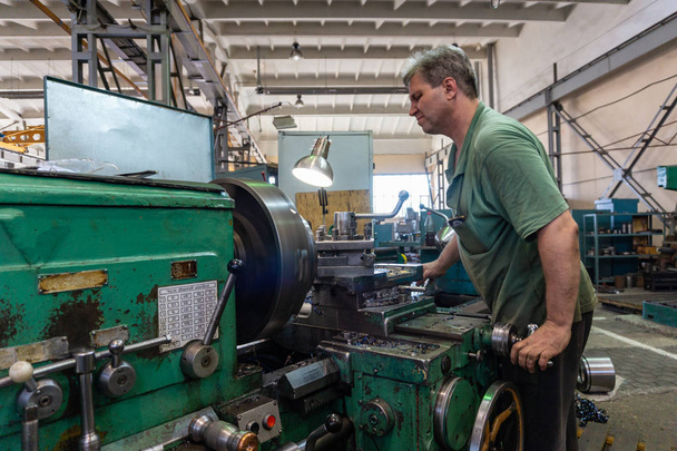 Arbeiter verwaltet die Ausrüstung der Schneidmaschine. Dreharbeiten in der Produktion - Foto, Bild