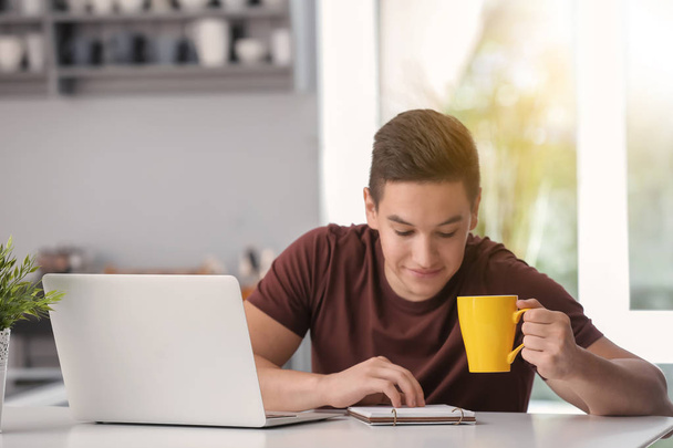 Mladí na volné noze pití kávy při práci v kuchyni - Fotografie, Obrázek