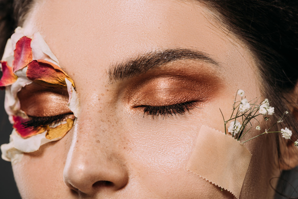 крупным планом женщина с макияжем на закрытых глазах и цветами на лице
  - Фото, изображение