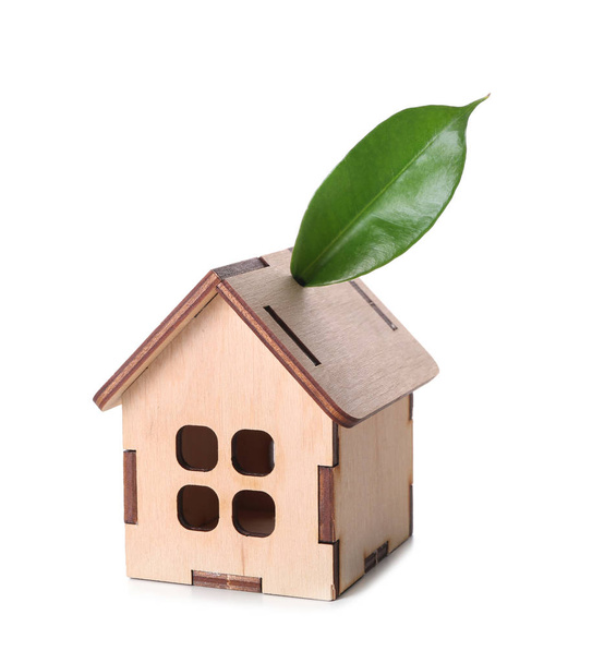 Drewniany model domu z zielonych liści na białym tle. Pojęcie ekologii - Zdjęcie, obraz
