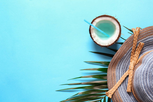 Komposition mit Strandhut, Kokosnusscocktail und tropischem Blatt auf farbigem Hintergrund - Foto, Bild