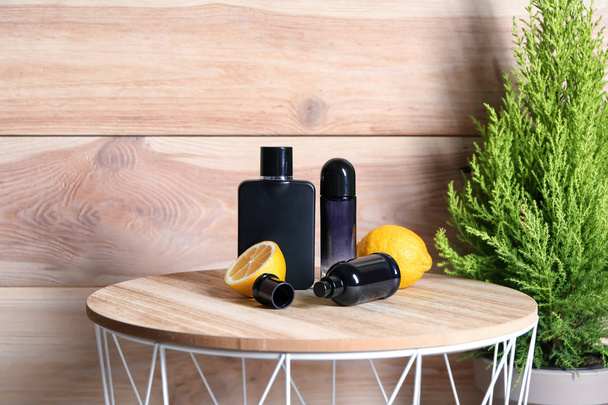 Bottles of male perfume and citrus fruit on wooden table - Valokuva, kuva