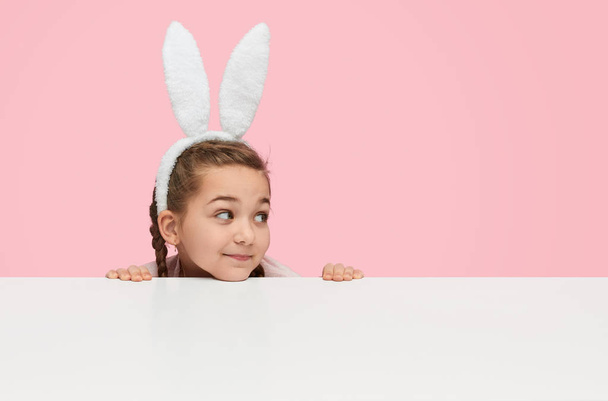 Playful little girl in white bunny ears  - Фото, изображение