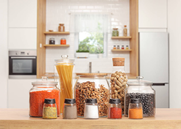 Many glass jars with different ingredients and spices on a kitchen worktop  - Foto, Imagem