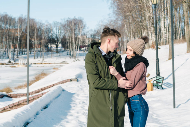 Νεαρό ζευγάρι με αγάπη στο πάρκο σε μια σαφή ηλιόλουστη χειμωνιάτικη μέρα - Φωτογραφία, εικόνα