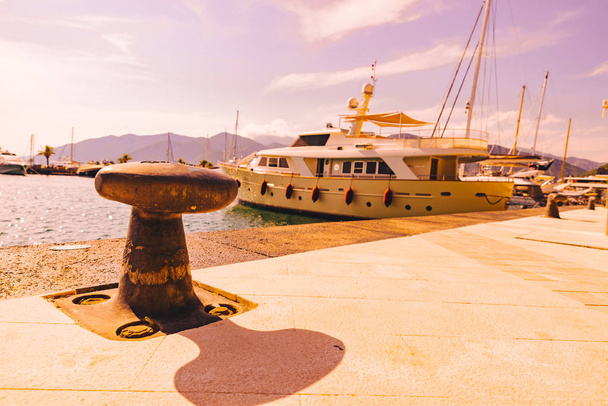 φωτιστικά τύπου bollard θάλασσα προβλήτα στο Μαυροβούνιο. βουνά στο φόντο. θερινή ώρα έννοια - Φωτογραφία, εικόνα