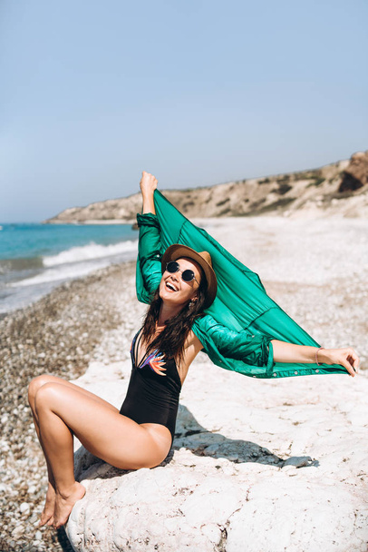Pretty pan asian travel girl relaxing on the beach at the sea in green pareo - Foto, Bild