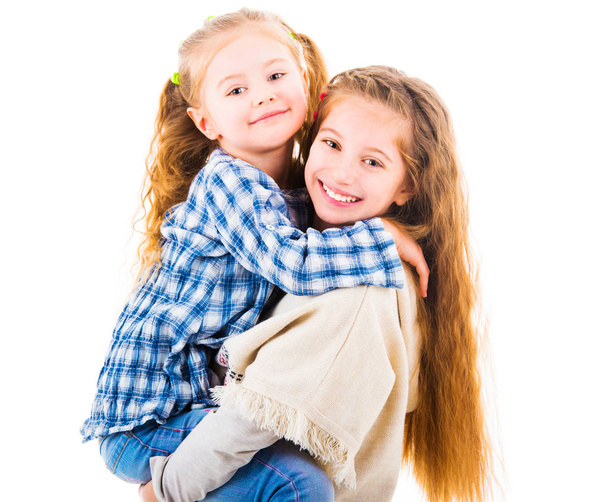 Chica sosteniendo a su hermana pequeña en sus brazos
 - Foto, Imagen