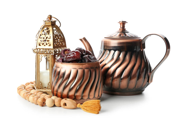 Vaso com datas saborosas, bule e lâmpada muçulmana no fundo branco
 - Foto, Imagem