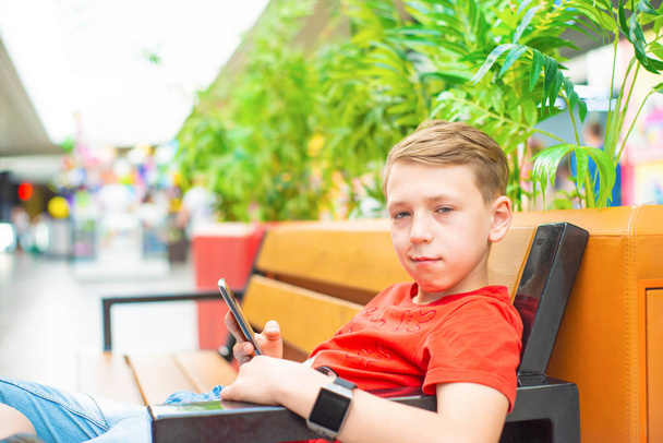 Chłopiec z smartphone na ławce - Zdjęcie, obraz