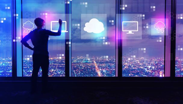 Το cloud computing με τον άνθρωπο από τα μεγάλα παράθυρα το βράδυ - Φωτογραφία, εικόνα