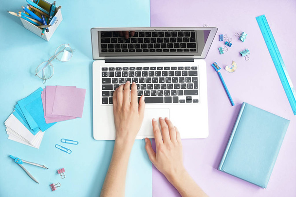 Женщина работает с ноутбуком на цветном фоне, вид сверху
 - Фото, изображение