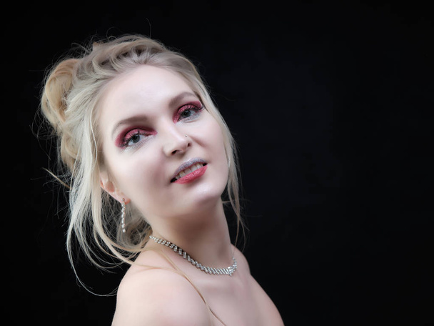 Beauty portrait of a smiling blond woman on a gray backdrop. Smiling girl with clean skin, natural make-up and white teeth on a gray background in a beauty salon - Φωτογραφία, εικόνα