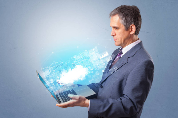 Man holding laptop with cloud based system notifications - Fotoğraf, Görsel
