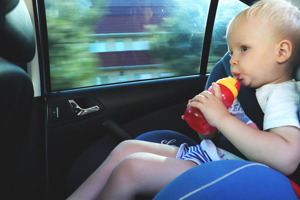 Портрет симпатичного хлопчика, який сидить на автокріслі. Безпека транспортування дітей
 - Фото, зображення