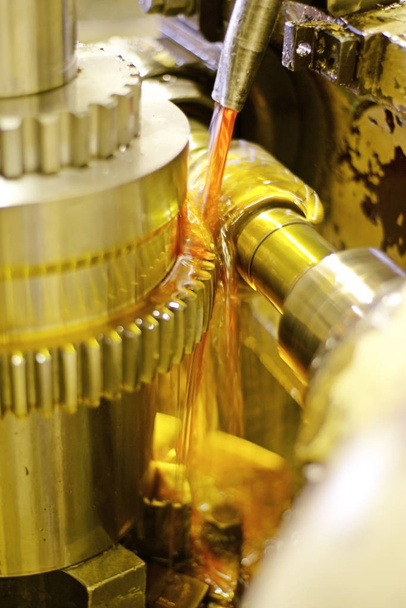 El cortador regula los flujos de metal y aceite de los troncos para refrigeración y lubricación. La industria de la metalurgia por corte, corte de engranajes de piezas y engranajes
. - Foto, imagen
