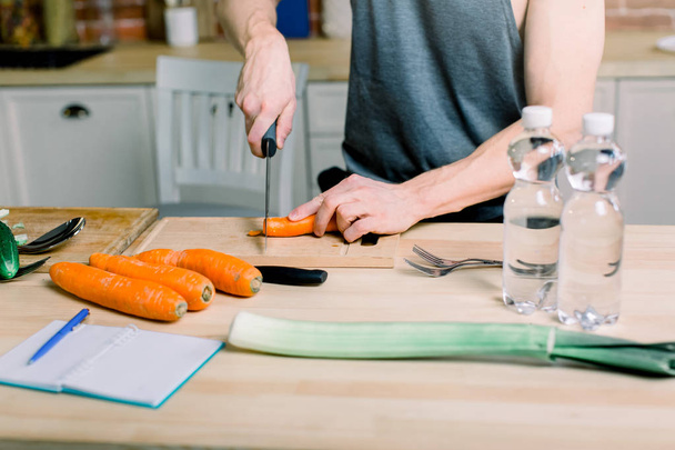 Υγιεινό τρόπο ζωής, υγιεινή διατροφή. Ένας νεαρός άνδρας ετοιμάζει μια σαλάτα από φρέσκα λαχανικά και φρούτα. - Φωτογραφία, εικόνα