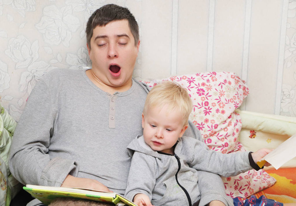 Papá le lee a su hijo un cuento para dormir.
 - Foto, Imagen