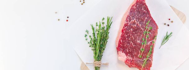 新鮮な生の牛肉肉サーロイン ステーキ ローズマリー タイム ハーブ ニンニク胡椒キノコ白い背景コピー スペースの創造的な平面図フラット レイアウト。食品の準備の料理コンセプトの長い広い旗 - 写真・画像