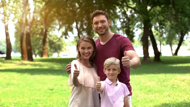 Smiling family showing thumbs up, happy secure life, togetherness and relax - Foto, Bild