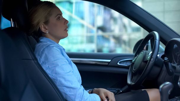 Frau nach Arbeitstag müde, im Auto sitzend, über Probleme nachdenkend - Foto, Bild