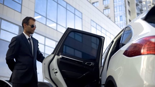 Responsible driver opening car door for his boss, luxury service, duties - Foto, Imagem
