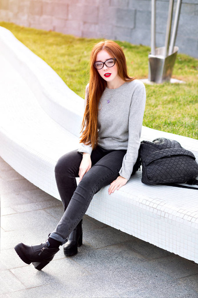 young beautiful woman in stylish glasses  sitting  on street  - Fotoğraf, Görsel