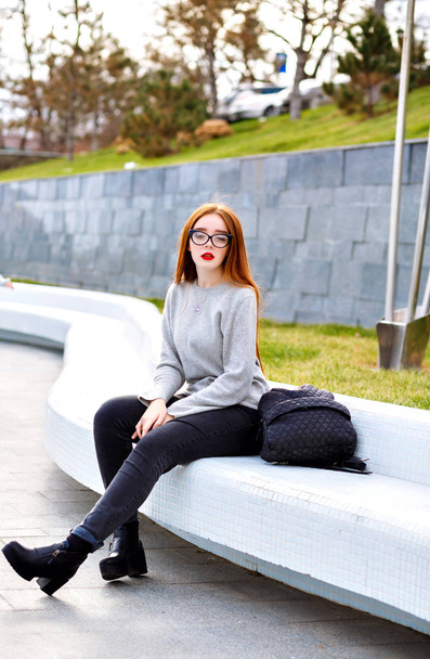 young beautiful woman in stylish glasses  sitting  on street  - Photo, image