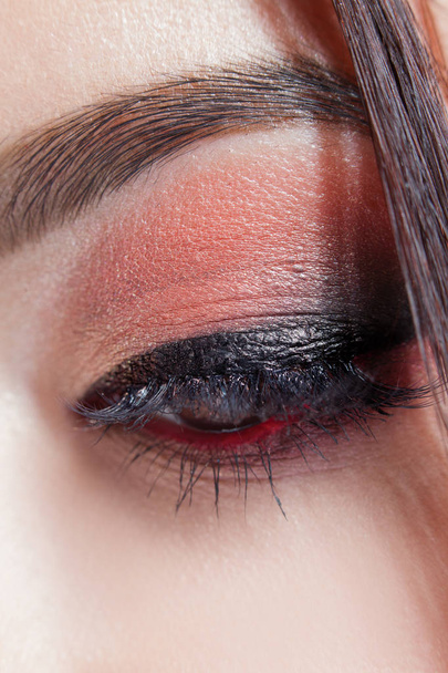 Amazing Bright eye makeup with a wide arrow. Brown and red tones, colored eyeshadow. - Fotó, kép