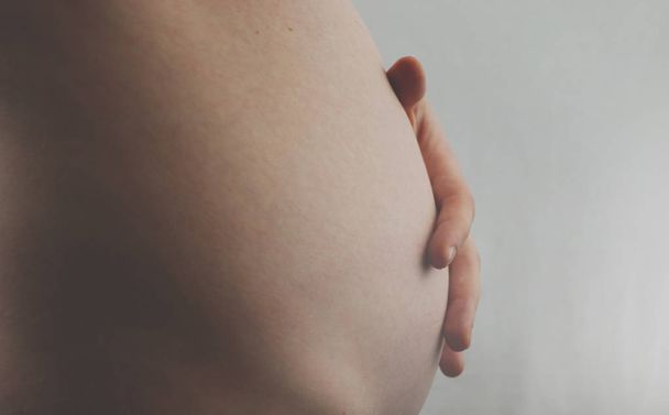 Schwangerschaftsbauch. Schwangerschaftskonzept. im dritten oder vierten Monat. zweites Trimester. Schwangerer Bauch aus nächster Nähe - Foto, Bild