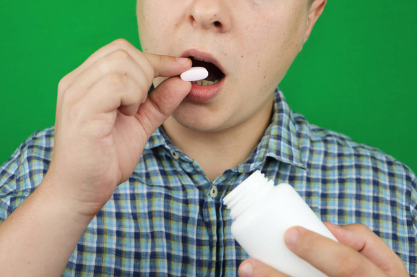 Hombre joven tomando una píldora
 - Foto, imagen
