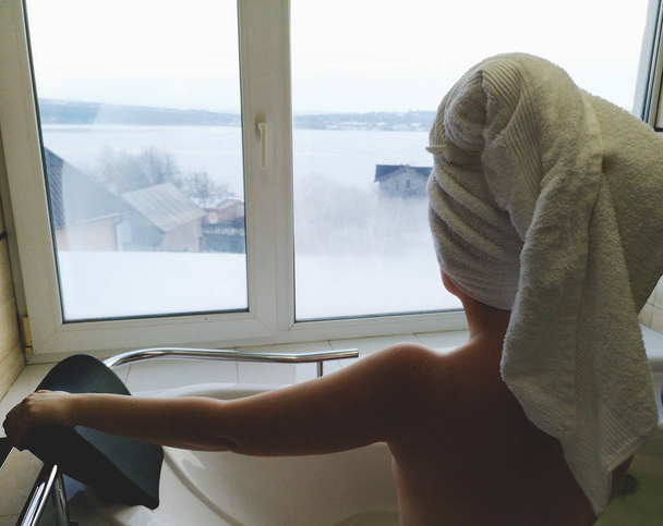 schöne Frau in einem Whirlpool. Jacuzzi im Hotel, Panoramablick aus dem Fenster im Badezimmer - Foto, Bild