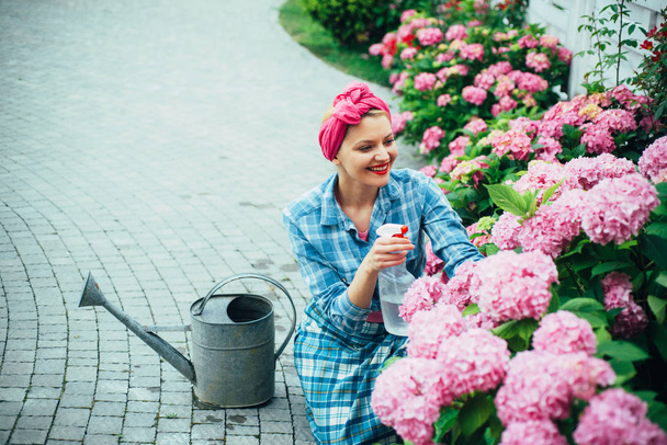 woman care of flowers in garden. Flower care and watering. soils and fertilizers. Greenhouse flowers. happy woman gardener with flowers. hydrangea. Spring and summer. I love to work with flowers - Foto, imagen