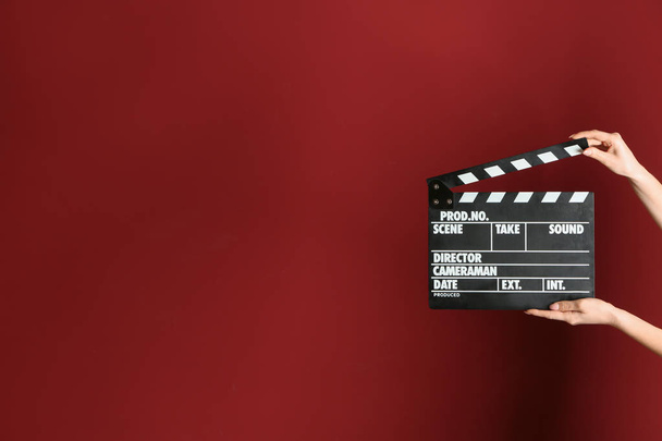 Female hands with cinema clapperboard on color background - Photo, Image