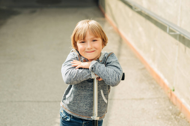 Πορτρέτο του αξιολάτρευτο νεαρό 4 ετών ακουμπά στο σκούτερ του ξανθό αγόρι - Φωτογραφία, εικόνα