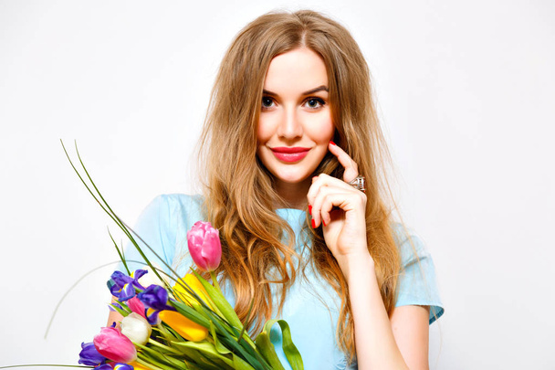 young surprised woman holding bunch of spring flowers  - Foto, afbeelding