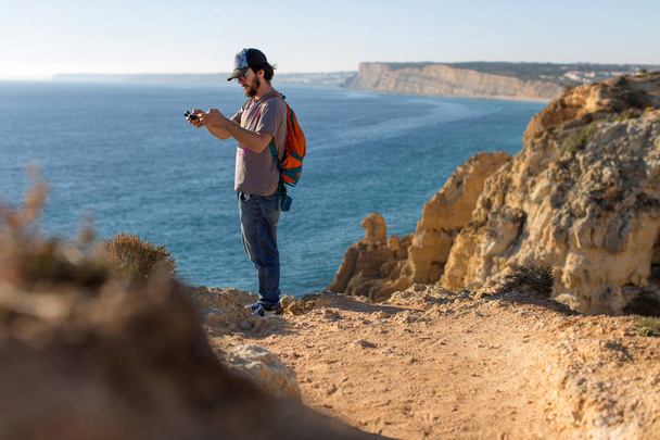 Homem a fotografar paisagens oceânicas, Ponta da Piedade perto de Lagos, Algarve, Portugal
 - Foto, Imagem